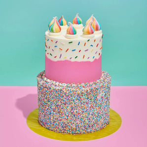 2 tier Birthday & Pinata Cake with rainbow sprinkles, colorful meringue drops, and vibrant sprinkle-covered base by Crumbs & Doilies.